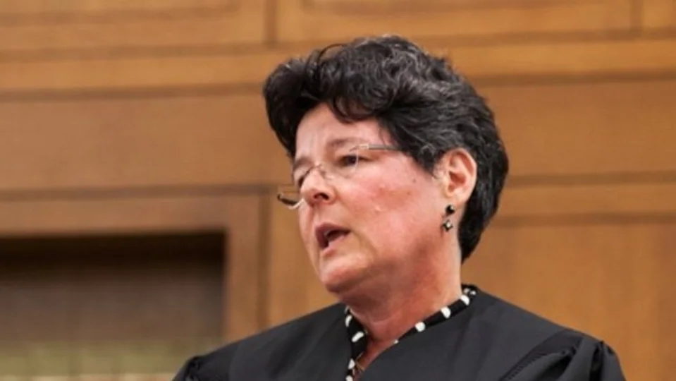 U.S. District Judge Allison D. Burroughs walking outside a federal courthouse in Boston, news photography style