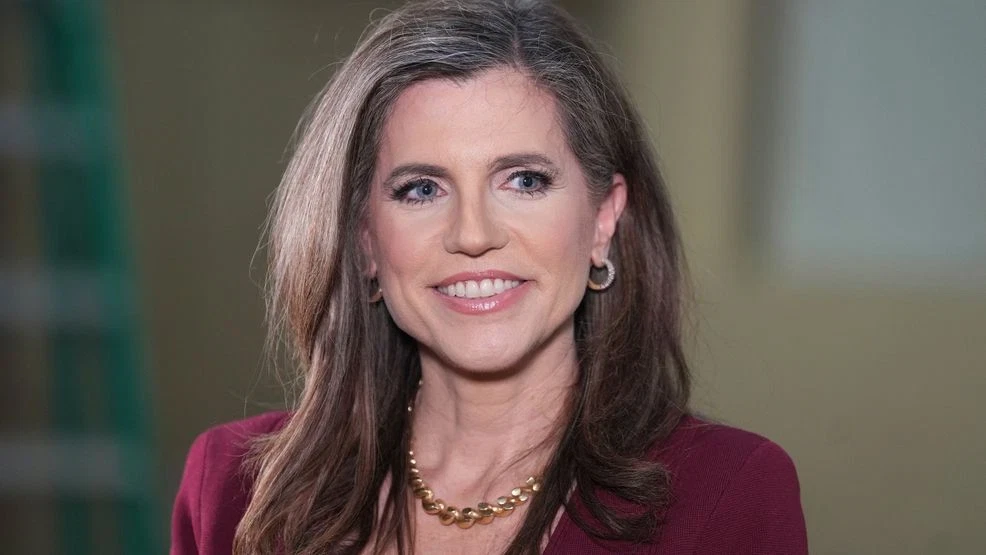 U.S. Representative Nancy Mace speaking at a public event with microphones in front of her