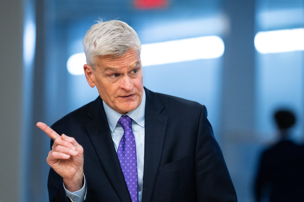 U.S. Senator Bill Cassidy speaking at a Senate hearing dais with microphones and nameplate visible, candid news photography