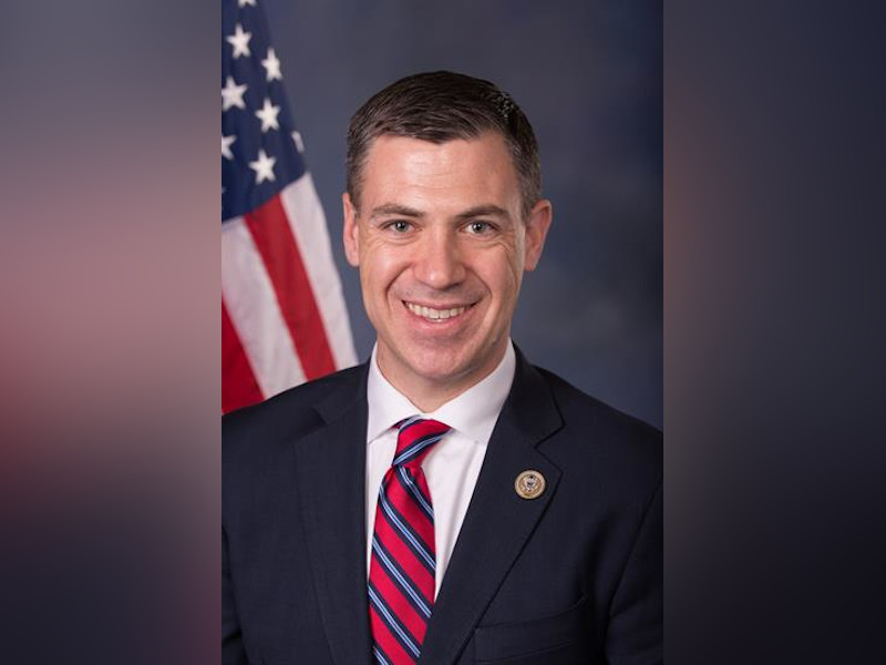 U.S. Senator Jim Banks speaking at a public event at a podium with a microphone