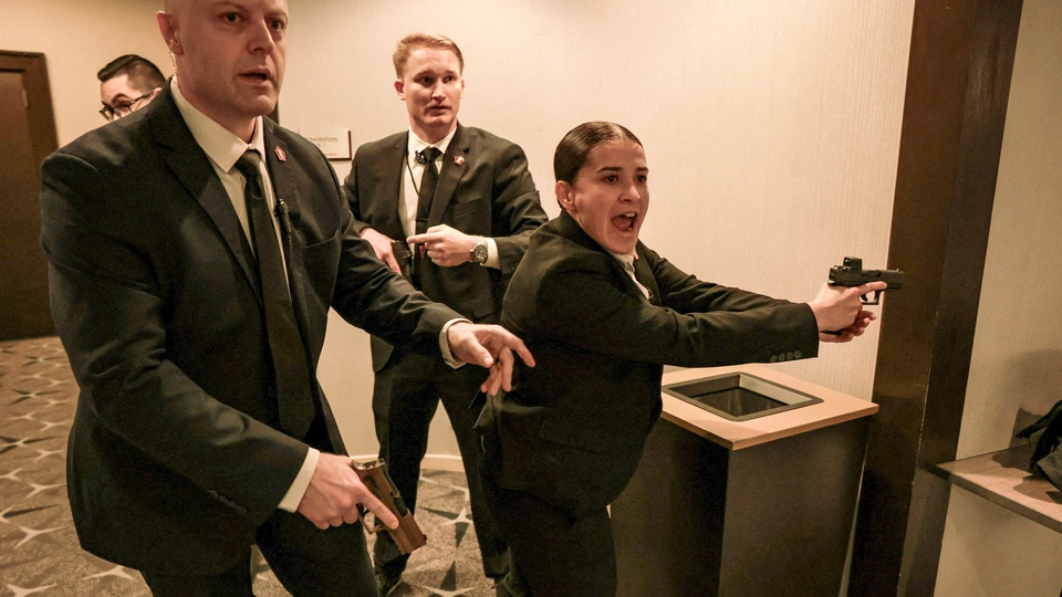 Uniformed federal security officers standing near metal barricades and screening checkpoints outside a major Washington, DC event venue at night, news photography style