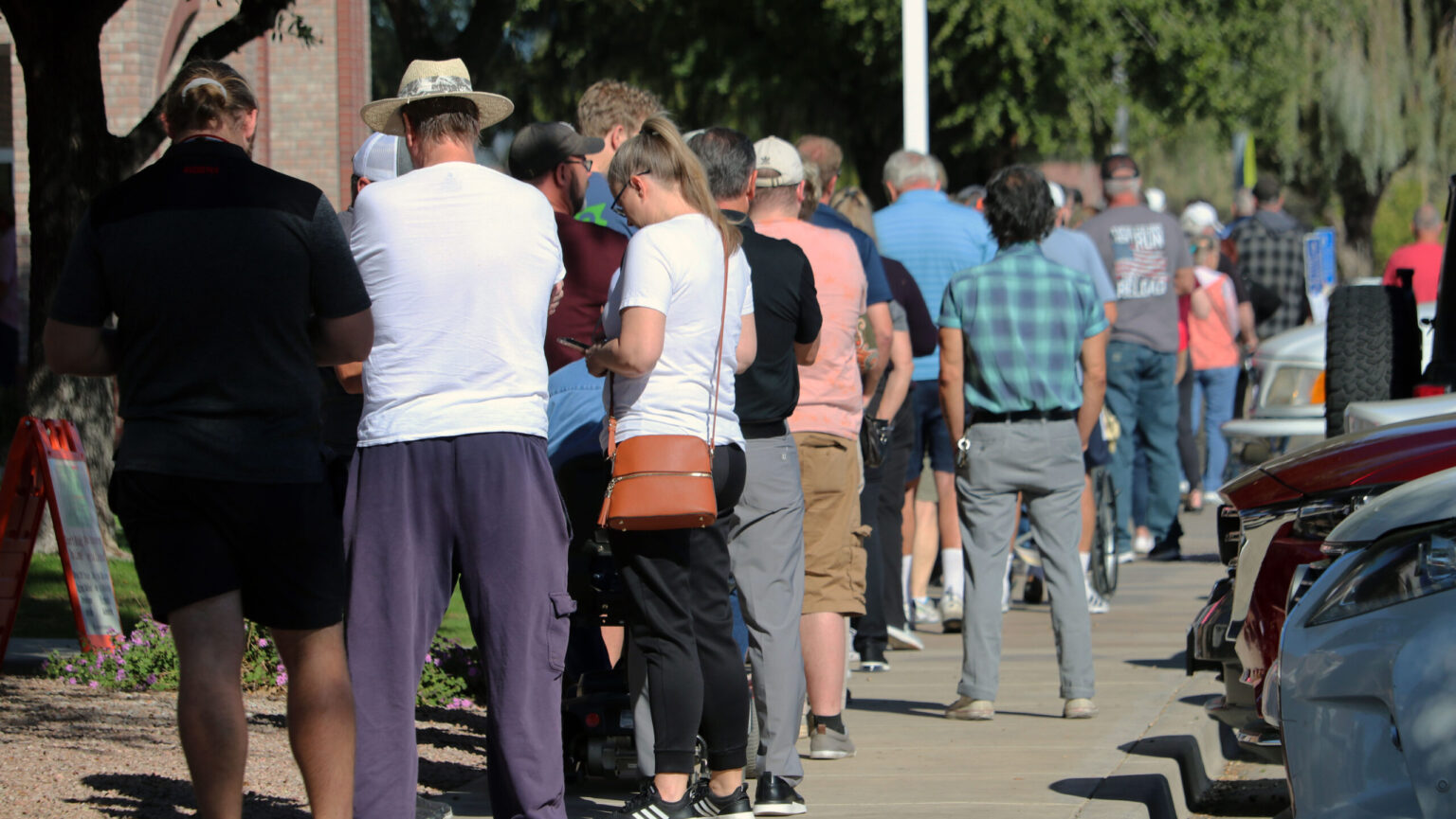 Voters standing in line outside a polling place in Arizona on a bright morning, news photography style