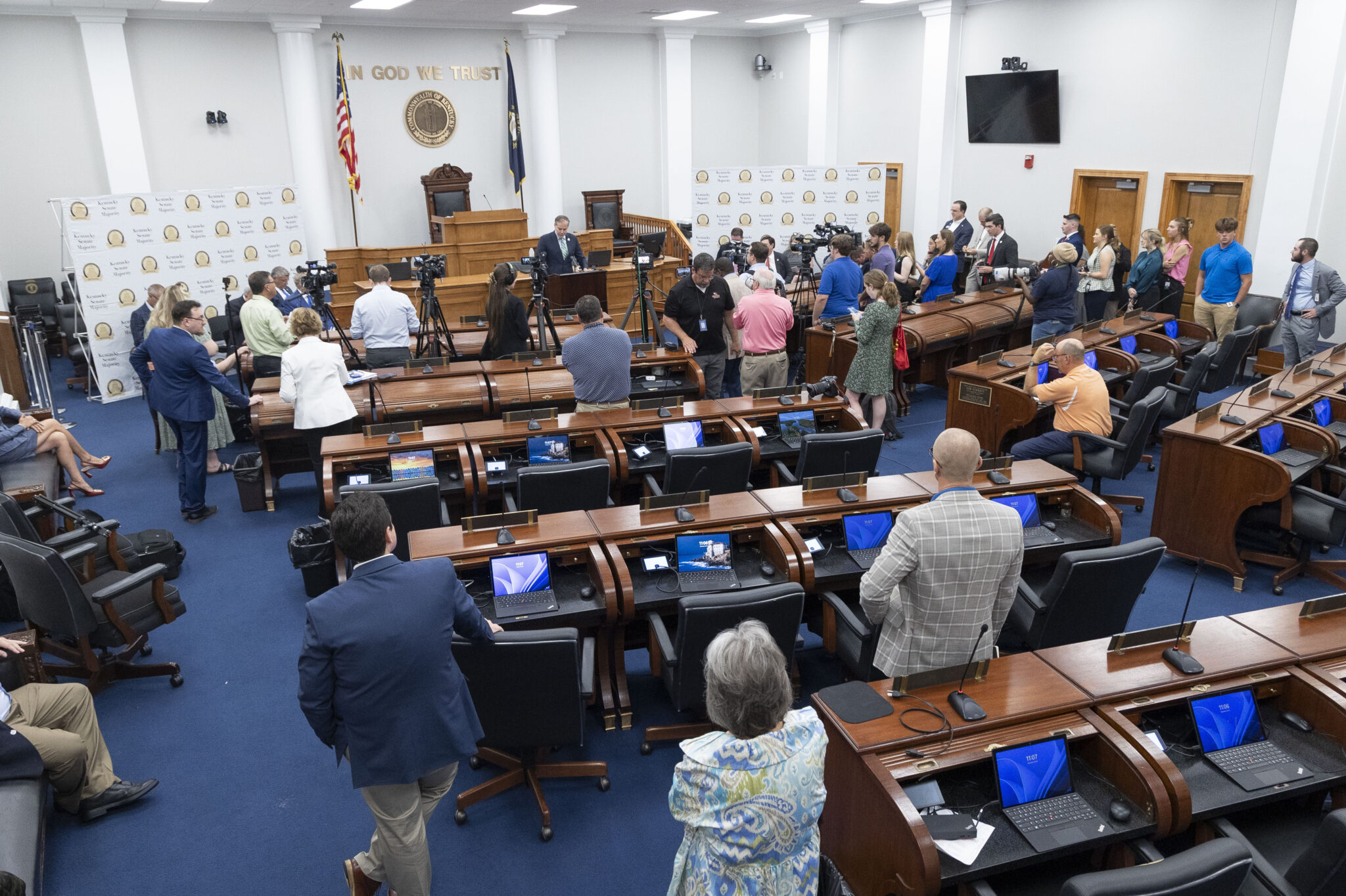 Wide view of the Kentucky state legislative chamber during a session with lawmakers seated at their desks, news photography style