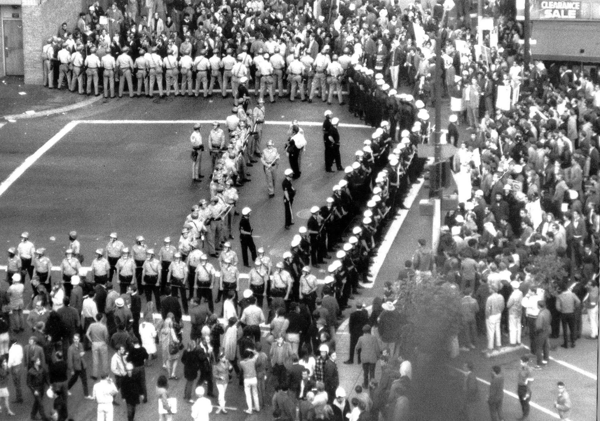 Young men standing in a line outside a draft board office in New York City in 1967, candid street photography style