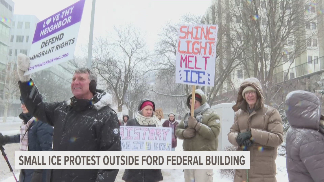 A group of protesters holding signs in front of a federal building