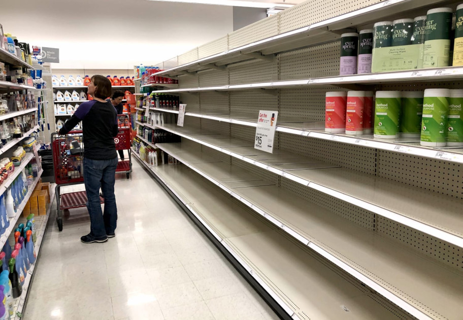 A person shopping in a store with nearly empty shelves