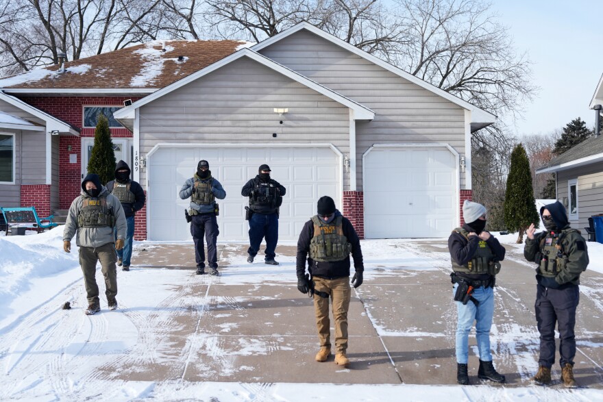 Federal immigration officers standing outside a federal building