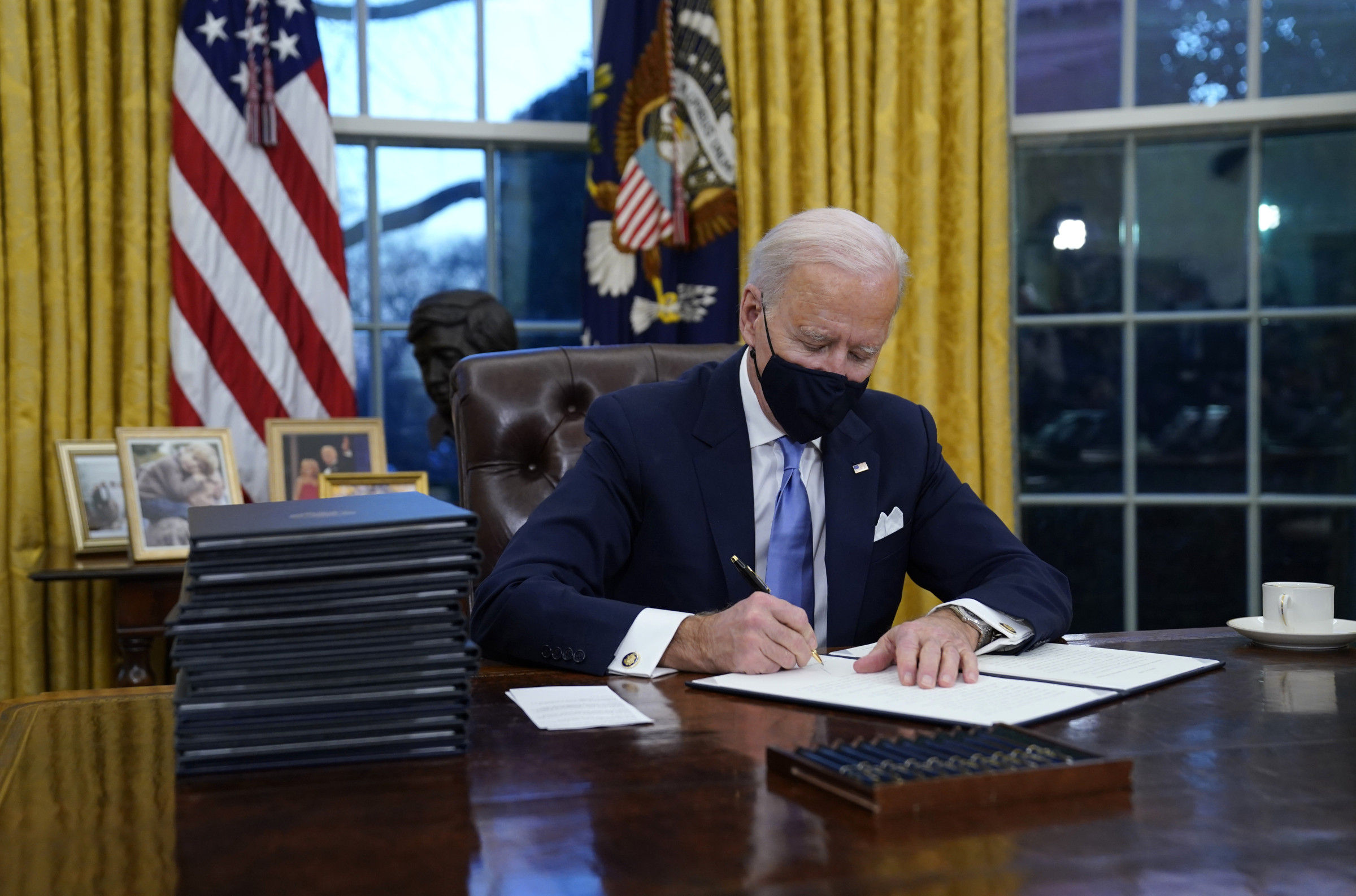 joe biden behind desk in oval office