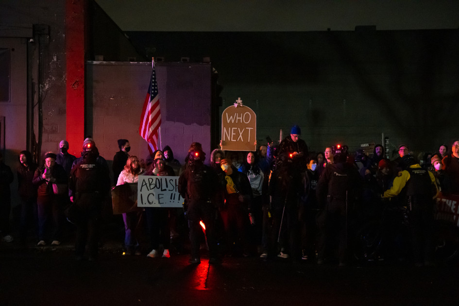 Portland protest signs about immigration enforcement with police line tape