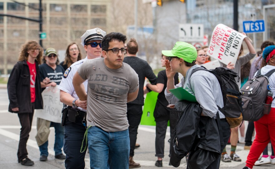 protesters with signs and legal observers with cameras