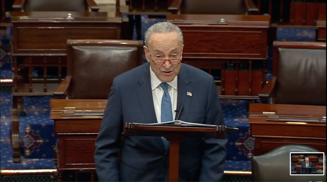 Senator Chuck Schumer speaking at a podium in the Capitol