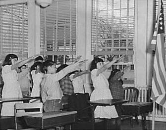 students saluting the american flag in school