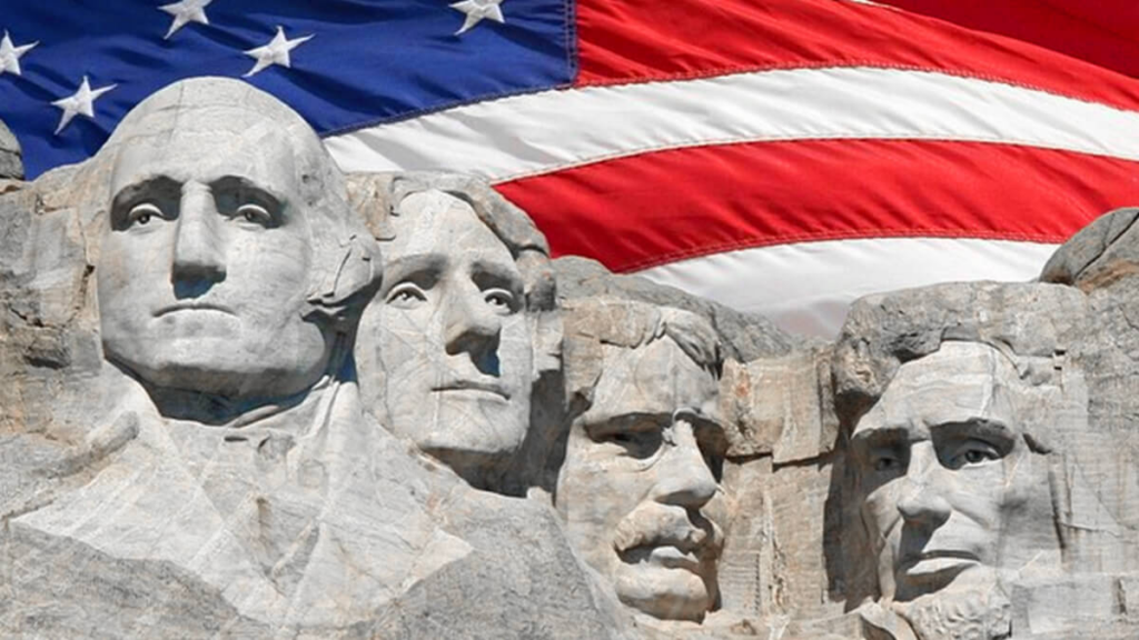 mount rushmore with american flag in background