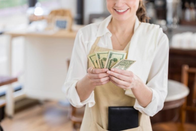 Waitress receiving cash tip from customer