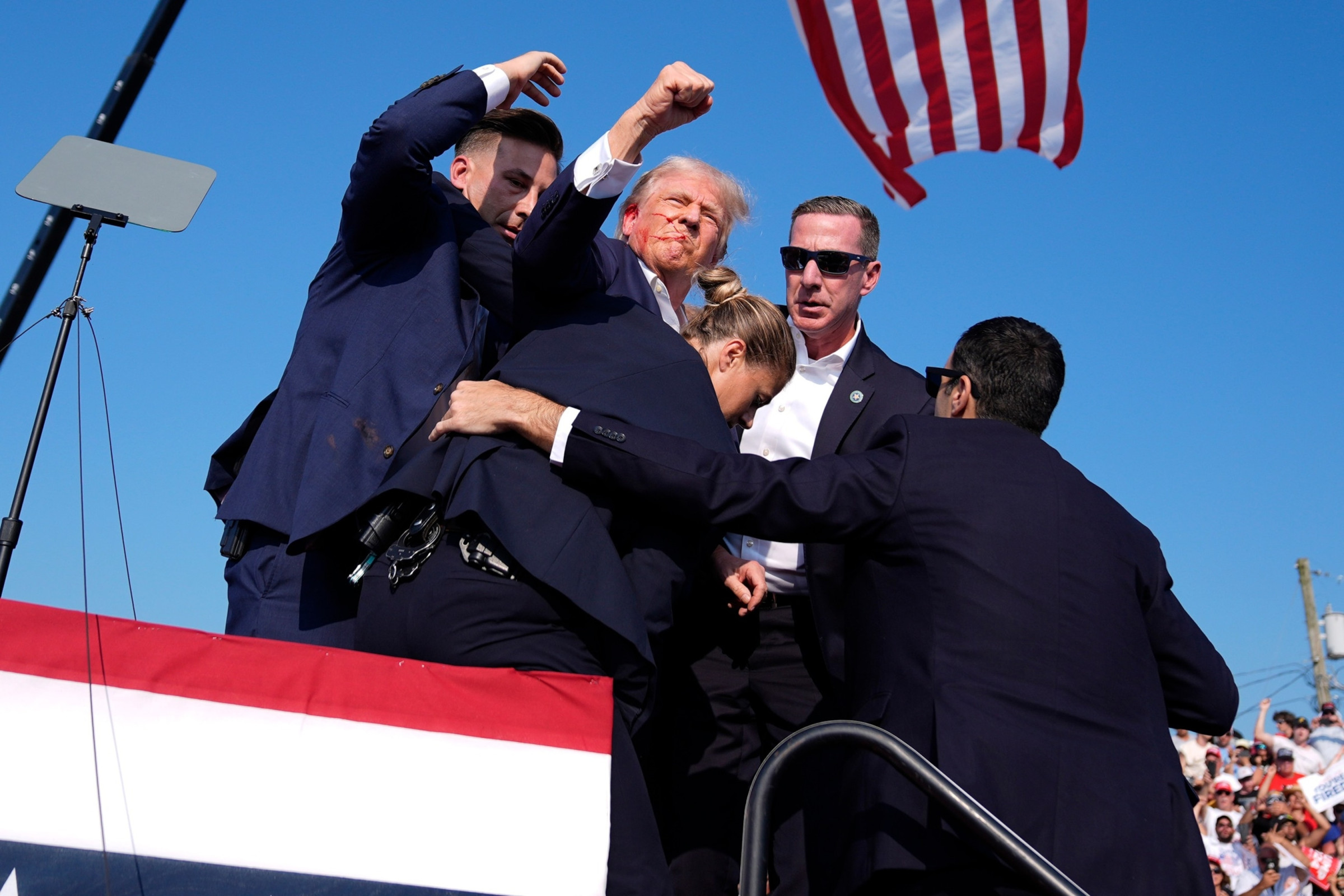 Donald Trump with blood on his face surrounded by Secret Service agents Butler Pennsylvania