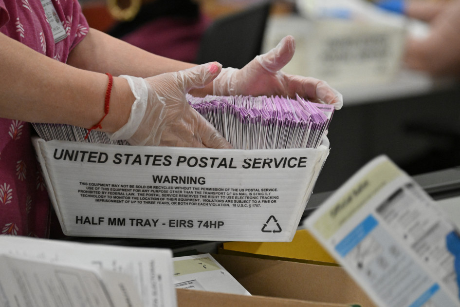 election worker processing mail-in ballots