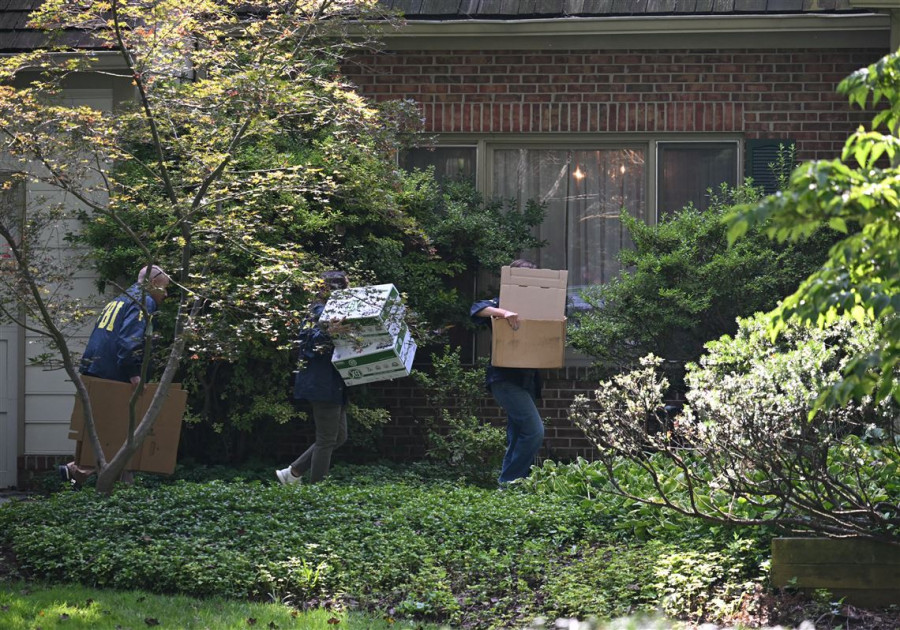 John Bolton waves outside of his home after FBI raid