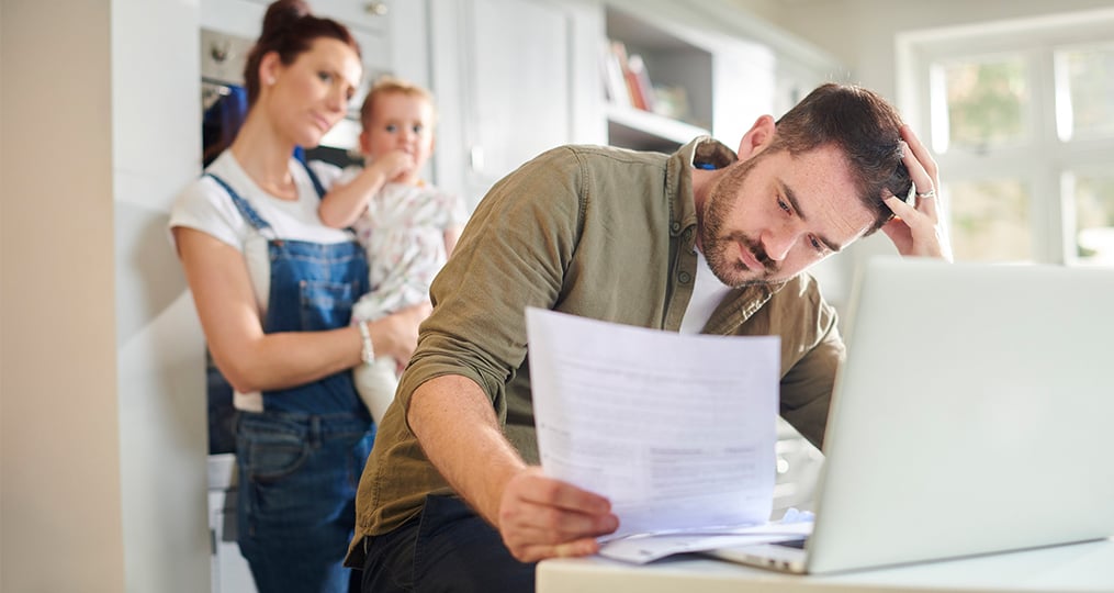 a family looking at bills at a kitchen table